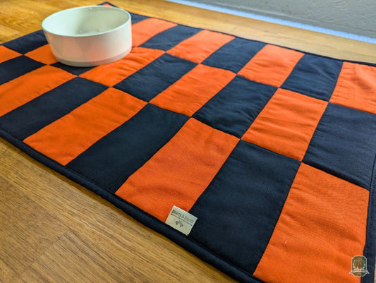 Angled image of Bright Orange and Black rectangles in an alternating pattern with a bowl on top