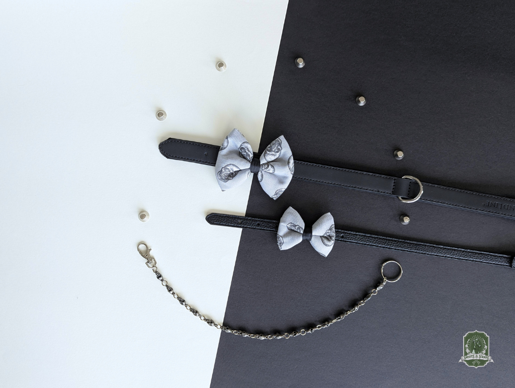 Grey skulls pattern dog and cat bow ties displayed on black leather collars