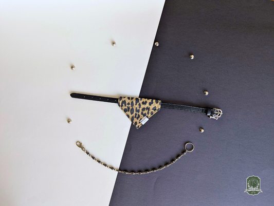 Leopard print pet bandana styled on a black collar on a black and white background
