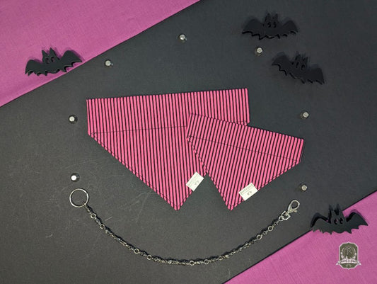 Pink and black striped dog bandana that slides onto a collar, with decorative chain on a black and pink background with bat decorations