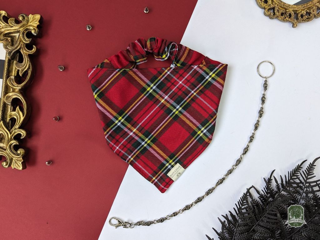 Red plaid dog bandana with a chain on a red and white background