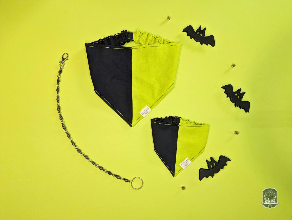Black and yellow dog bandana with bat decorations on a yellow background