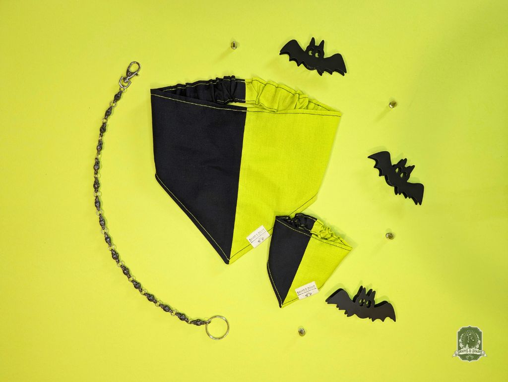 Black and yellow dog bandana with elastic collar with bat decorations on a yellow background