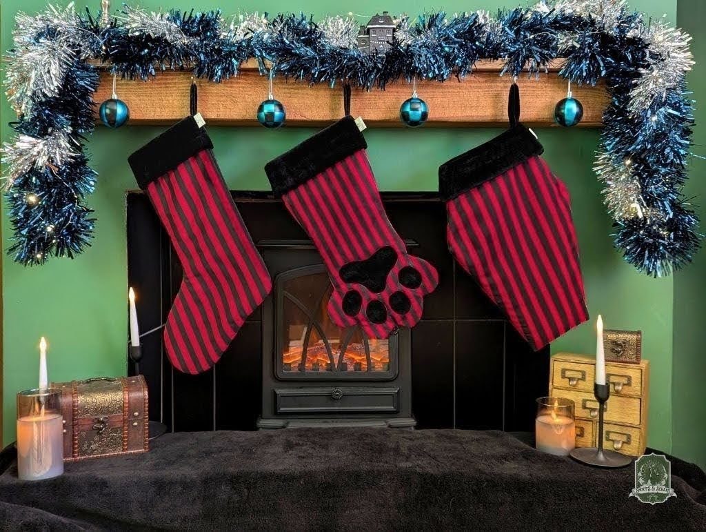 Red and black striped stockings hanging above a fireplace with tinsel decorations.