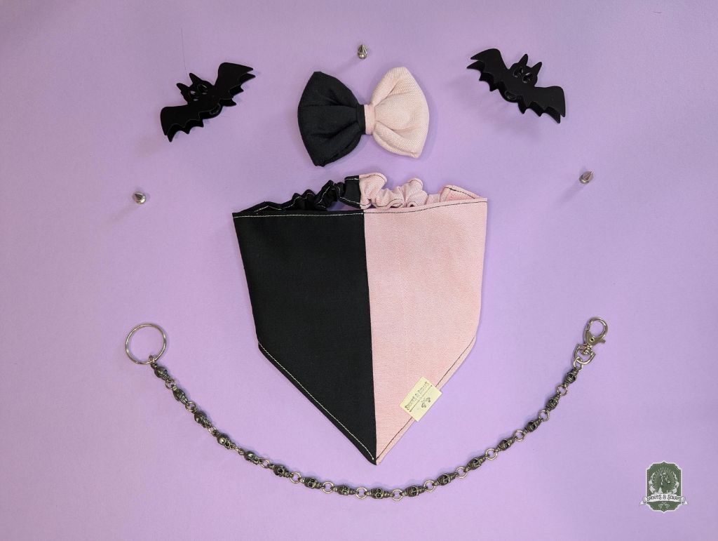 Black and pink dog bandana with matching pet bow tie, and black bats on a purple background.