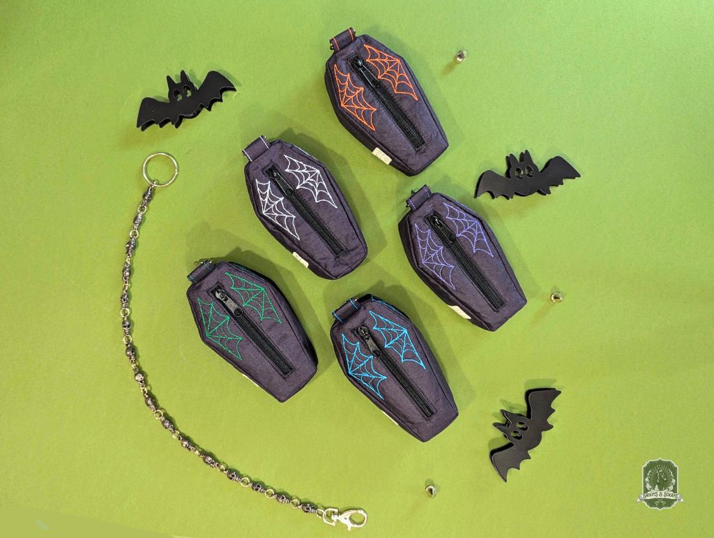 Halloween-themed dog poop bag holders and dispensers with coffin-shape designs on a green background