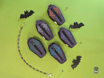 Halloween-themed dog poop bag holders and dispensers with coffin-shape designs on a green background