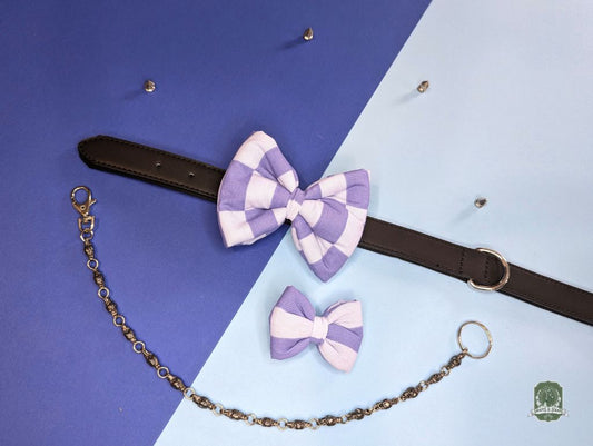 Pastel blue and light blue checkered dog bow tie with a  decorative chain on a blue and purple gradient background