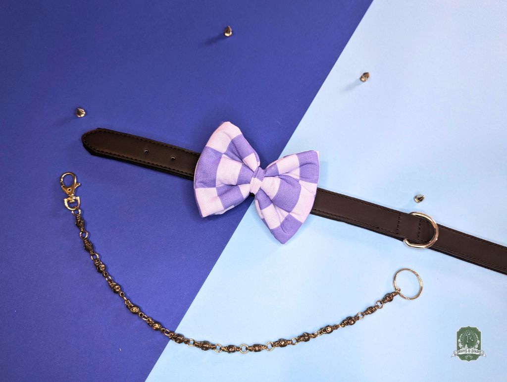 Purple checkered bow tie with brown leather strap and chain on a blue and blue gradient background.