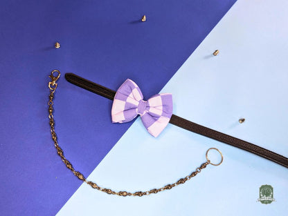 Checkered pastel blue and light blue pet bow tie with a chain on a blue and purple gradient background