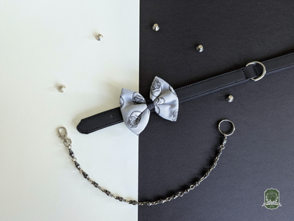 Grey skulls pattern pet bow tie displayed on black leather collar