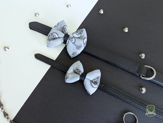 Grey skulls pattern pet bow ties displayed on black leather collars
