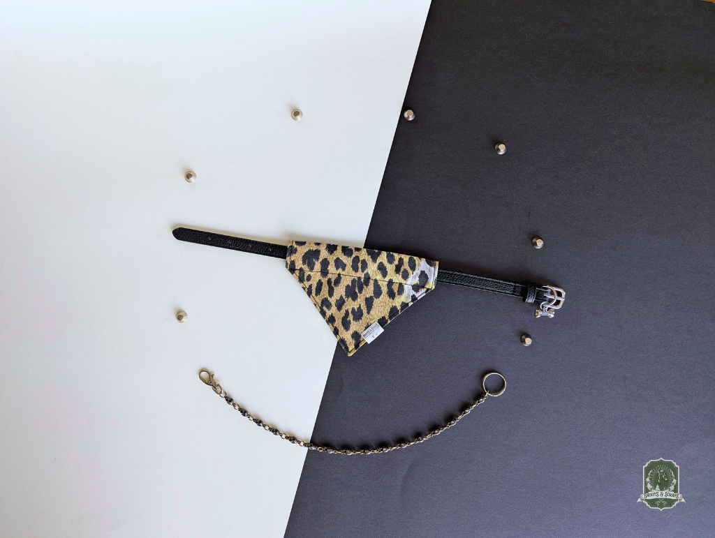 Leopard print pet bandana styled on a black collar on a black and white background