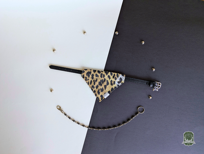Leopard print pet bandana styled on a black collar on a black and white background