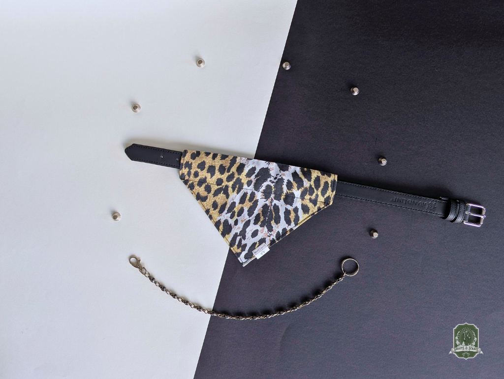Leopard print pet bandana styled on a black collar on a black and white background