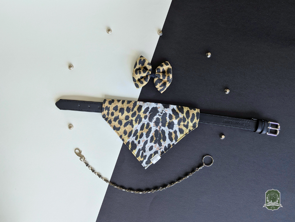 Leopard print pet bandana and bow ties styled on a black collar on a black and white background