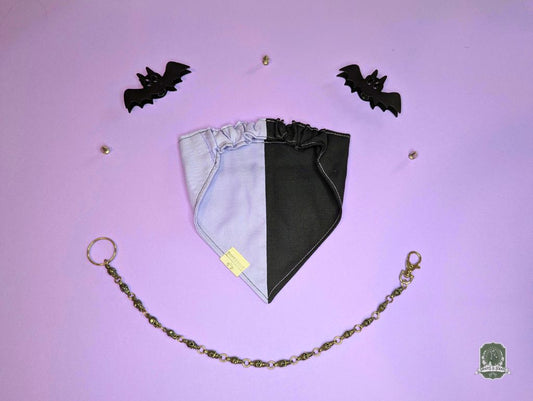 Black and lilac dog bandana with elasticated collar on a purple background with decorative bats.