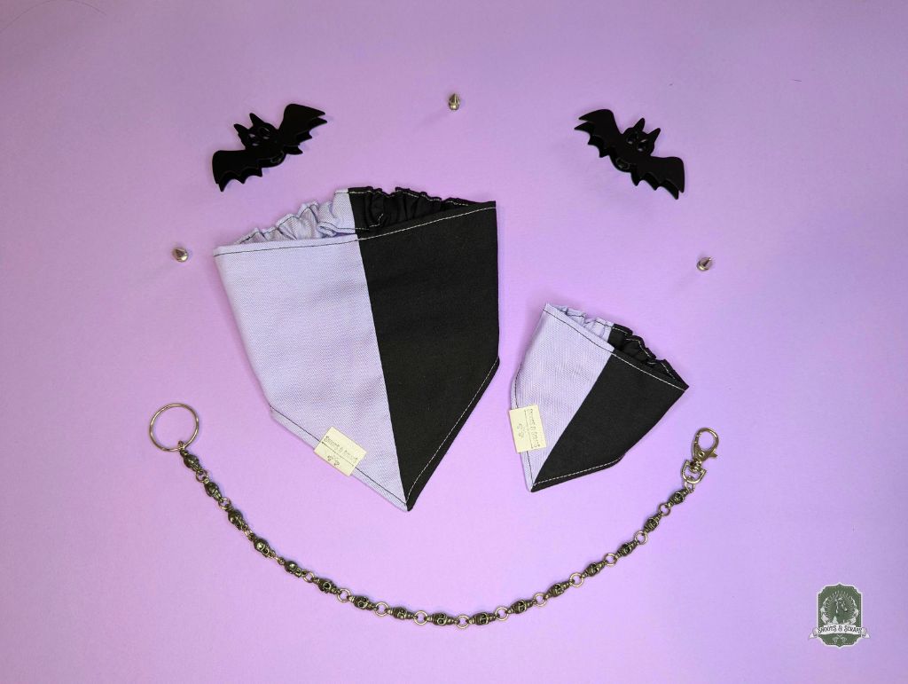 Dog bandana with black and lilac colour block design on a pink background with decorative bats.