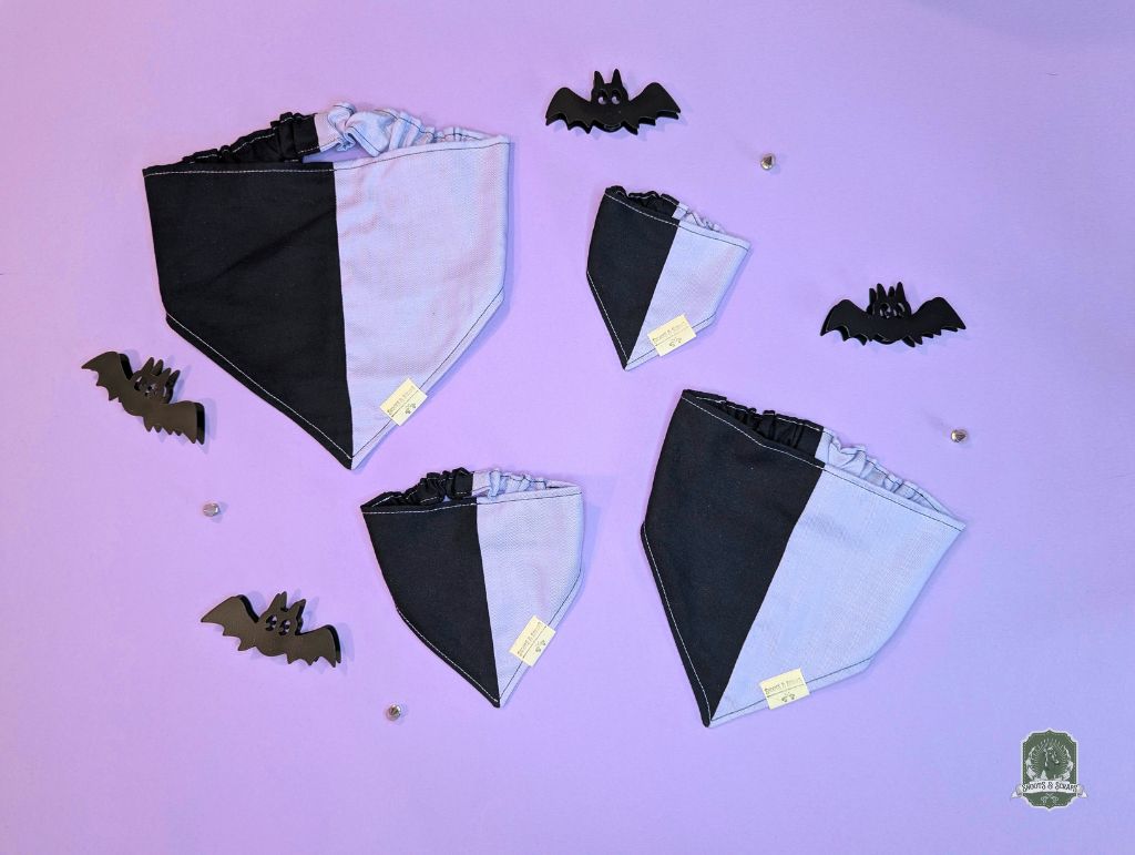 Black and lilac elastic dog bandanas with bat decorations on a purple background