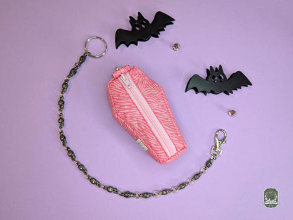 pink zebra print coffin shaped poop bag holder on pink background