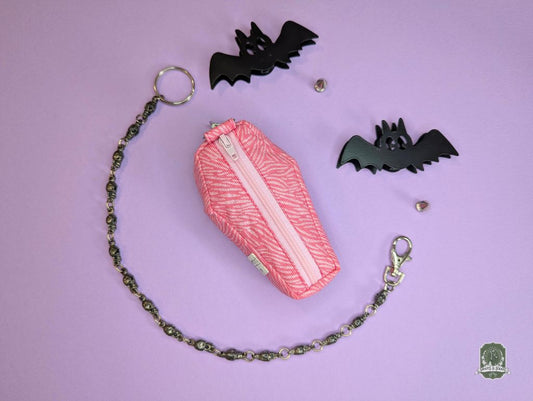 pink zebra print coffin shaped poop bag holder on pink background