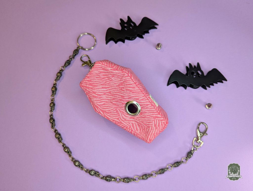 pink zebra print coffin shaped poop bag holder on pink background
