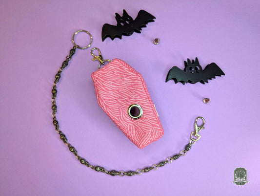 pink zebra print coffin shaped poop bag holder on pink background