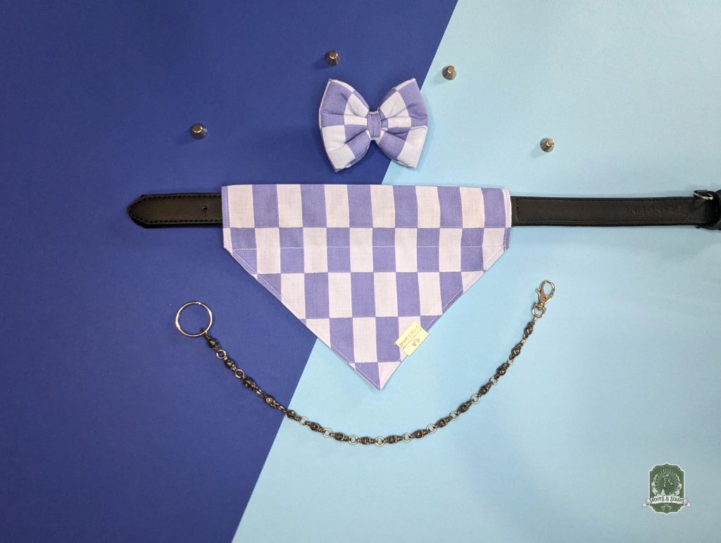 Pet bandana with checkered pattern, bow tie, and chain on a blue and blue two-tone 
background