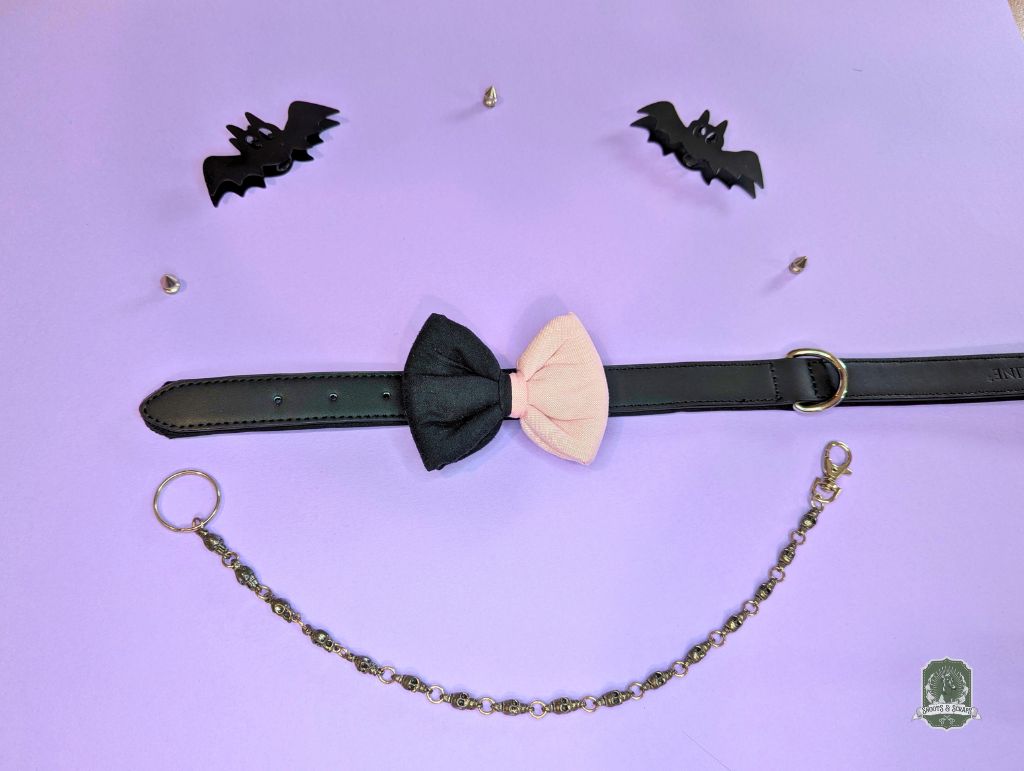Pastel Pink and black Pastel goth dog cat bow tie displayed on a leather collar on purple background
