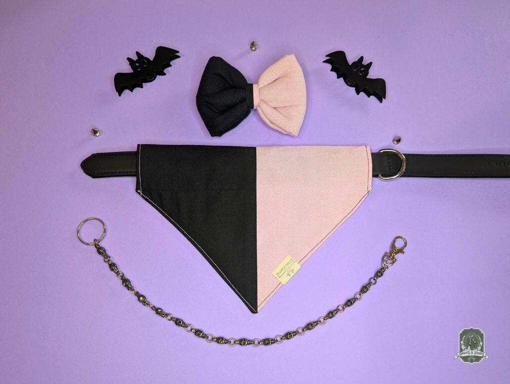 Black and pink dog  bandana and bow tie collar with decorative chain on a purple background