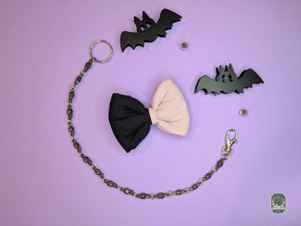 Black and pink pet bow ties with decorative chain on a purple background