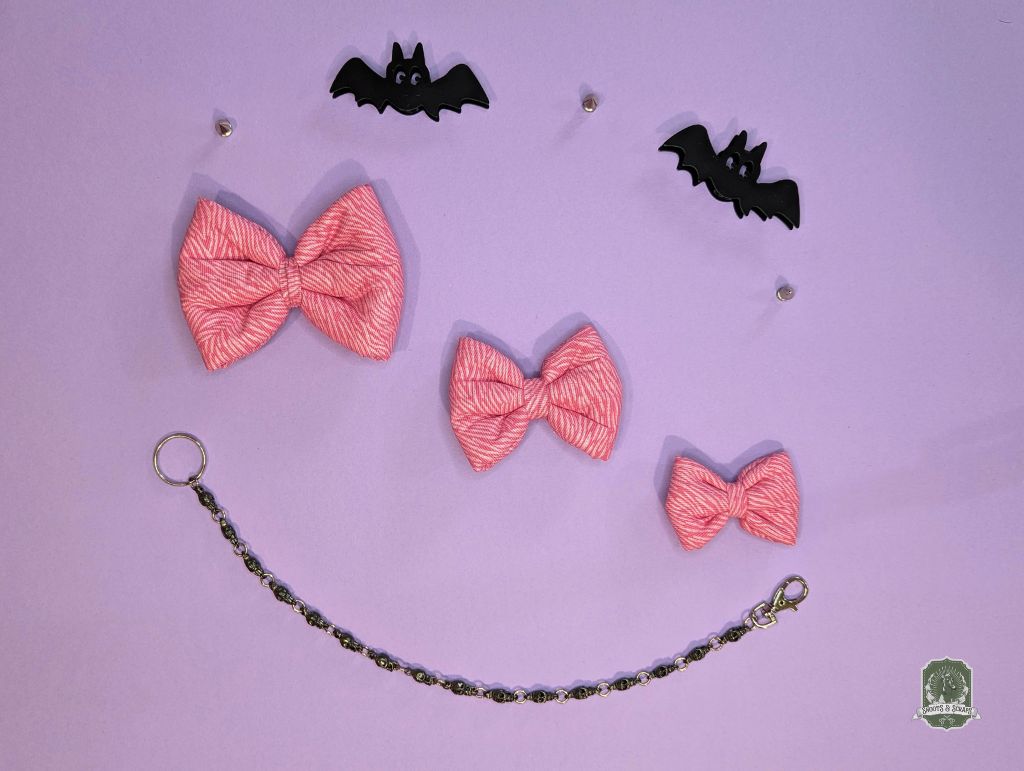 Pink zebra print pet bow ties displayed on a pastel pink background and decorative chain.
