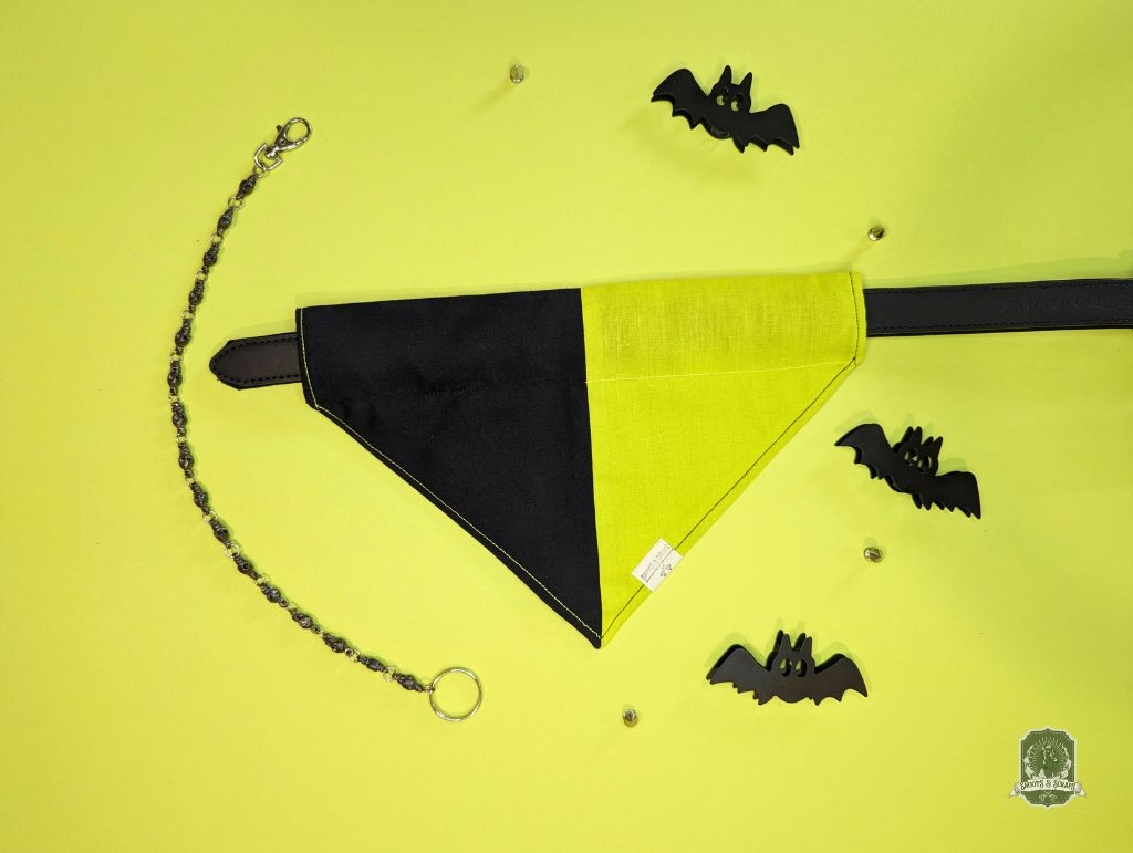 Black and yellow dog bandana with bat decorations on a yellow background