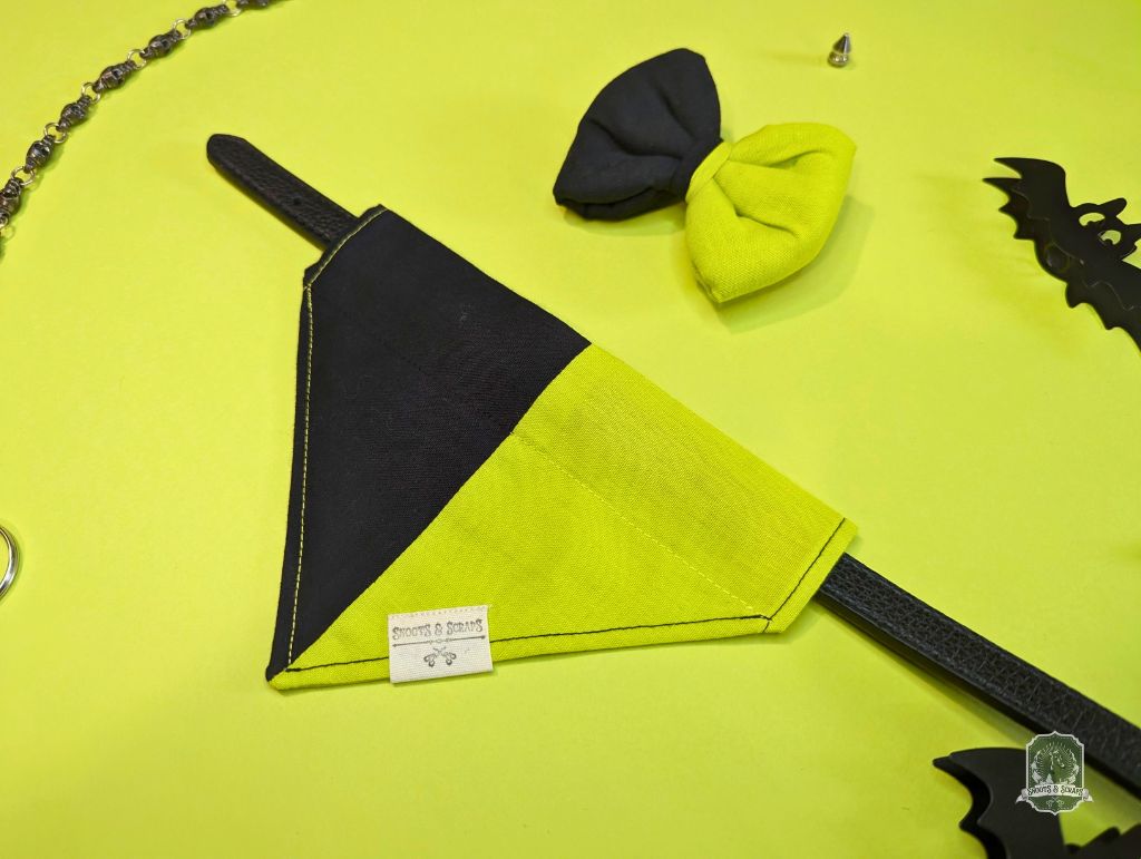 Black and yellow dog bandana with matching pet bow tie on a green background