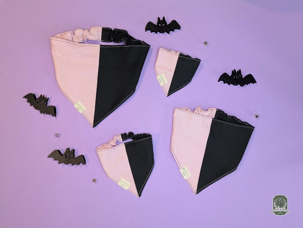 Black and pink dog bandanas with decorative bats on a purple background