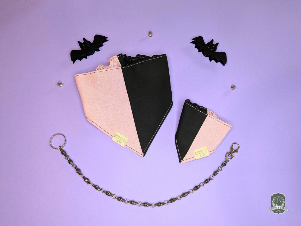 Black and pink dog bandana with elastic collar on a purple background