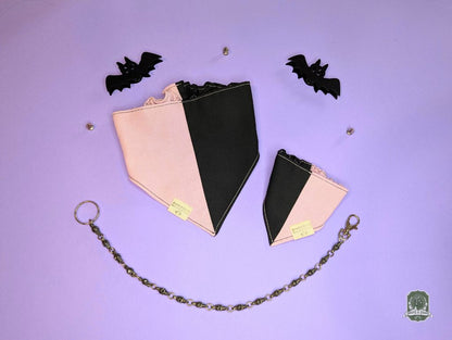 Black and pink dog bandana with elastic collar on a purple background