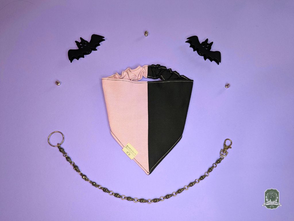 Black and pink dog bandana with elastic collar on a purple background