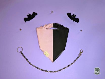Black and pink dog bandana with elastic collar on a purple background