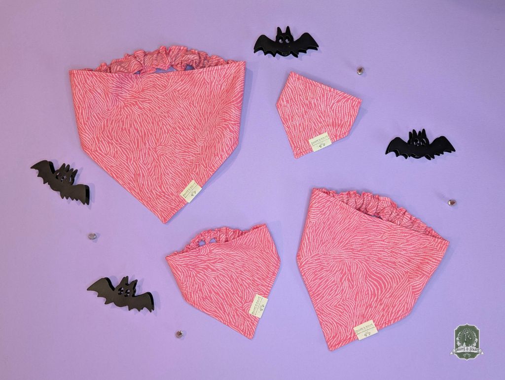 Pink zebra print elastic pet bandanas on a purple background