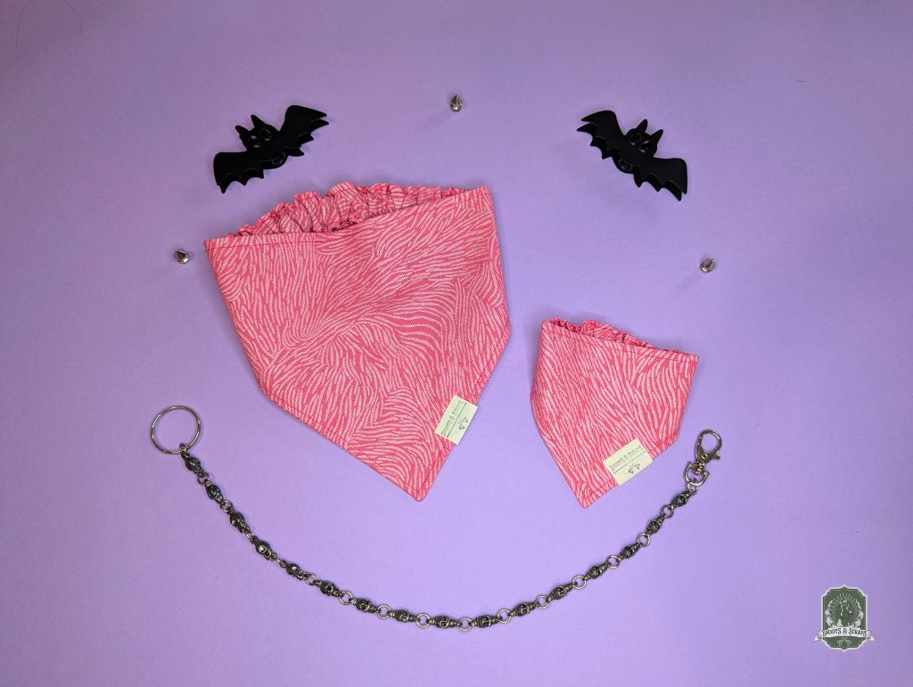 Pink zebra print elastic pet bandanas on a purple background