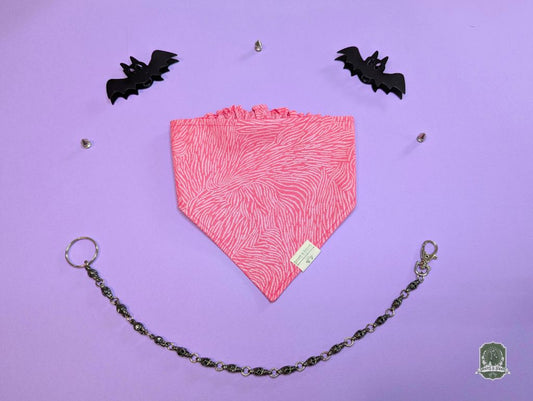 Pink zebra print elastic pet bandana on a purple background