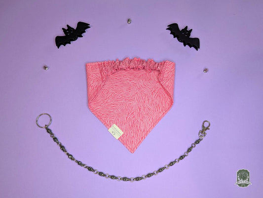 Pink zebra print elastic pet bandana on a purple background
